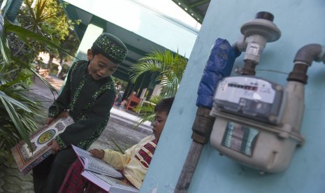 Dua santri bermain disamping meteran penyaluran gas bumi PGN di Tempat Pendidikan Alquran, Masjid Ummul Mu'minin, Surabaya, Jawa Timur, Selasa (19/7). 