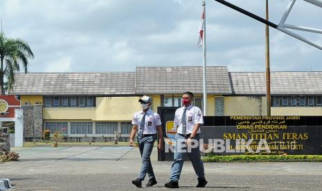 Dua siswa berjalan di halaman depan kompleks SMAN Titian Teras H. Abdurrahman Sayoeti, Jambi Luar Kota, Muarojambi, Jambi, Senin (14/2/2022). Data Dinas Pendidikan Provinsi Jambi menyebutkan sebanyak 37 siswa di sekolah itu terkonfirmasi positif COVID-19, namun pembelajaran tatap muka (PTM) tetap berlangsung dengan penerapan protokol kesehatan serta pembelajaran jarak jauh (PJJ) juga tetap dilakukan.