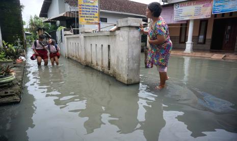 Dua siswa berjalan menerobos banjir rob (ilustrasi)