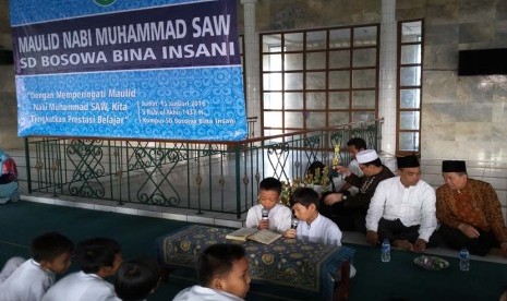 Dua siswa SD Bosowa Bina Insani membaca Al-Qur'an pada peringatan Maulid Nabi Muhammad SAW di Masjid Al-Ikhlas Sekolah Bosowa Bina Insani Bogor, Jawa Barat, Ahad (15/1).