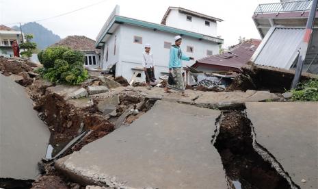  Dua siswa sekolah berjalan melewati pesantren mereka yang runtuh akibat gempa bermagnitudo 5,6, di Cianjur, Rabu (23/11/2022). Pemprov Jawa Tengah dinilai perlu memperbanyak Kampung Siaga Bencana.