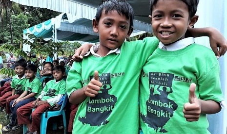 Dua siswa TK Islahul Ummah tampak bahagia dengan dibangunnya kembali sekolah mereka yang sebelumnya luluh lantak.