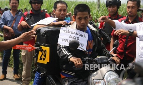 Dua tersangka pembunuhan, Azis Prakoso (kanan) dan Aris Sugianto (kiri) membawa koper berisi mayat saat rekonstruksi di Kediri, Jawa Timur, Rabu (24/4/2019). 