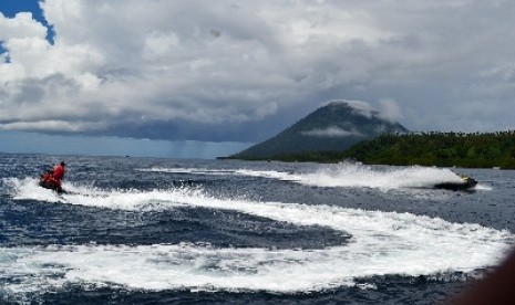 Dua turis sedang menampilkan kebolehannya sambil berolahraga mengemudikan Jetsky sekaligus menikmati panorama objek wisata Taman Nasional Bunaken, Sulawesi Utara, Minggu (10/2). 