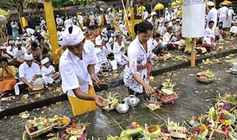 Dua umat Hindu menyiapkan sesajen dalam perayaan hari suci Kuningan (ilustrasi)