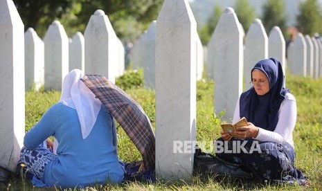 Dua wanita Bosnia membacakan doa di Potocari Memorial Center Srebrenica Bosnia Herzegovina di sela peringatan 22 tahun pembantaian ribuan muslim Bosnia oleh tentara Serbia.