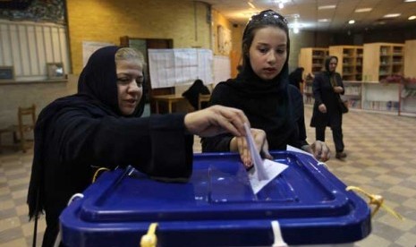 Dua wanita Iran memberikan suara mereka saat pemilihan presiden Iran di Teheran, Jumat (14/6).