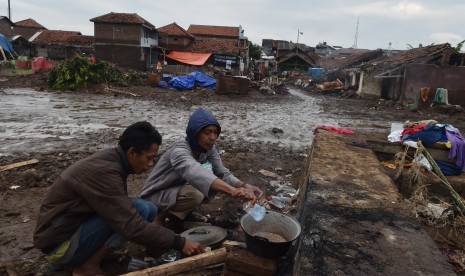 Dua warga beraktivitas di lokasi bangunan yang rusak akibat banjir bandang aliran Sungai Cimanuk di Kampung Cimacan, Tarogong, Kabupaten Garut, Jawa Barat, Jumat (23/9). 