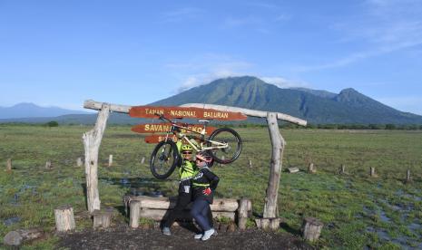 Dua warga berpose saat berolahraga di Sabana Bekol Taman Nasional Baluran, Situbondo, Jawa Timur, Ahad (12/6/2022). 