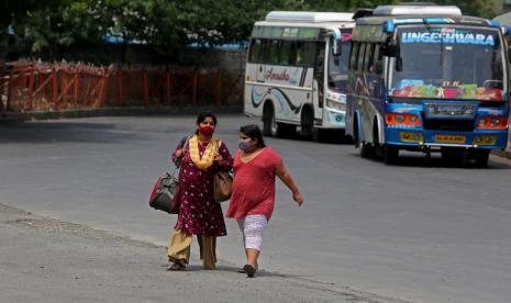 Dua warga India sedang menunggu bus di Bangalore, India. 