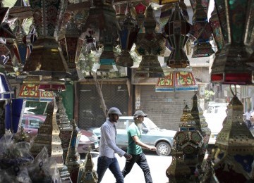 Dua warga melintasi toko yang dipenuhi lentera tradisional di Cairo, Mesir, Senin (18/7). Menyambut Ramadhan, warga Mesir membeli lentera berwarna-warni ini untuk menghiasi rumahnya.