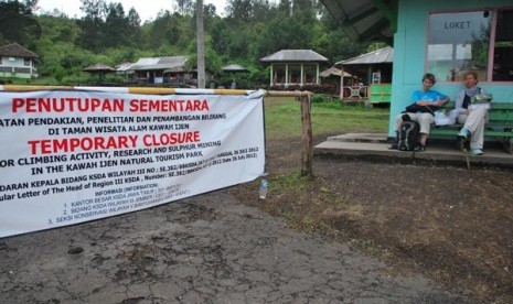 Dua wisatawan asing duduk dipintu masuk Gunung Ijen, Licin, Banyuwangi, Jawa Timur, Jumat (11/1). Pusat Vulkanologi dan Mitigasi Bencana Geologi melarang semua aktivias dalam radius 1,5 Km dari bibir kawah, baik berupa penambangan belereng, pendakian Gunun