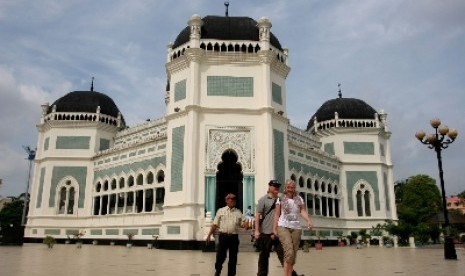 Dua wisatawan mancanegara bersama seorang pemandu ketika mengunjungi Masjid Raya Al-Mashun, Medan, Sumut, Selasa (5/6). Pihak Dinas Kebudayaan dan Pariwisata Kota Medan menyatakan, kunjungan wisatawan mancanegara ke Medan meningkat 20 persen dari bulan seb