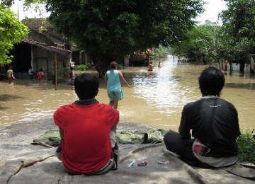 Dua warga menunggu surutnya air luapan Bengawan Solo 