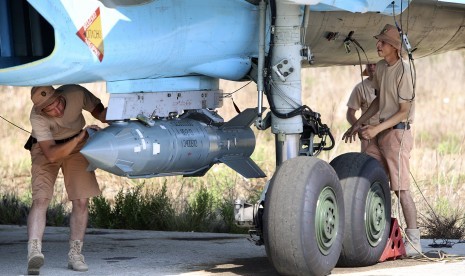 Dukungan militer Rusia yang sedang mempersiapkan bom ke pesawat tempur SU-35 di pangkalan udara Hmeimim, Suriah, Sabtu (3/10).