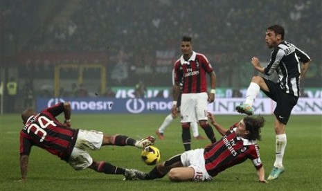 Duo gelandang AC Milan, Nigel De Jong, dan Riccardo Montolivo, berjibaku untuk menahan tendangan pemain Juventus, Claudio Marchisio. Pertandingan lanjutan Serie A yang berlangsung di San Siro, Senin (26/11) itu berhasil dimenangkan Milan 1-0.