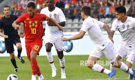 Eden Hazard mengiring bola melewati pemain Potrugal  dalam pertandingan sepak bola persahabatan antara Belgia dan Portugal di stadion King Baudouin di Brussels, Sabtu (2/6).