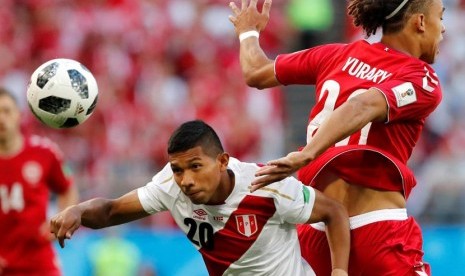 Edison Flores (Peru) berebut bola dengan pemain Timnas Denmark Yussuf Poulsen.