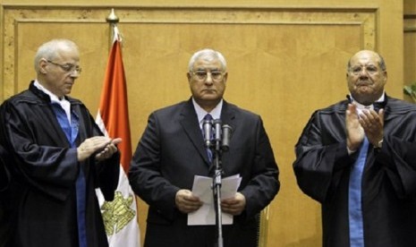 Egypt's chief justice Adly Mansour, center, is applauded by by chiefs of the constitutional court after he is sworn in as the nation's interim president Thursday, July 4, 2013. 