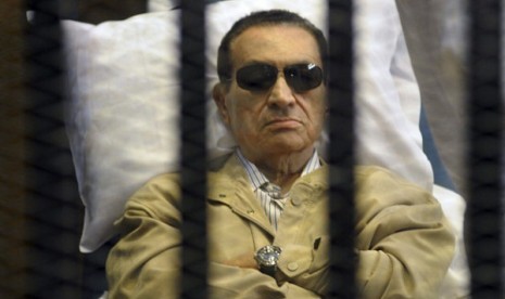 Egypt's ex-President Hosni Mubarak lays on a gurney inside a barred cage in the police academy courthouse in Cairo, Egypt.   