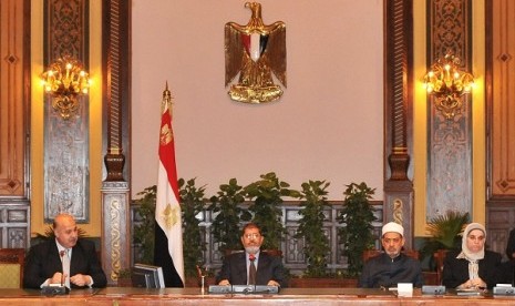 Egypt's President Mohamed Mursi (center) attends a meeting with Egypt's Vice President Mahmoud Mekky (left) with other politicians and heads of parties at the presidential palace in Cairo December 8, 2012. Mursi offers concession by cancelling a decree which has sparked huge protests by giving him sweeping powers. 