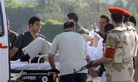 Egyptian medics and military policemen escort former Egyptian president Hosni Mubarak into an ambulance after after he was flown by a helicopter ambulance to the Maadi Military Hospital from Torah prison in, Cairo, Egypt, Thursday, Aug. 22, 2013. 