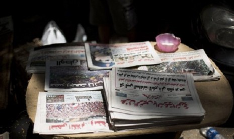 Egyptian newspapers are seen in a street kiosk near Cairo University in Cairo, Thursday, July 4, 2013. The chief justice of Egypt's Supreme Constitutional Court was sworn in Thursday as the nation's interim president, taking over hours after the military o