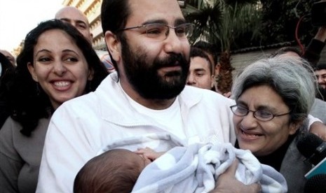  Egyptian prominent blogger Alaa Abdel-Fattah (center), hugs his recently born son, Khaled, in Cairo, Egypt, in 2011. (File photo)