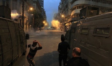 Egyptian security forces try to disperse protesters demonstrating against the government on a street off Cairo's Tahrir Square on Sunday, Dec. 1, 2013. 