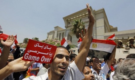 Egyptians celebrate in front of the constitutional court after Egypt's chief justice Adly Mansour was sworn in as the nation's interim president Thursday, July 4, 2013. Arabic reads, 