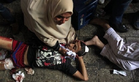 Egyptians lay on the ground after being injured during clashes between security forces and supporters of Egypt's ousted President Mohammed Morsi in Ramses Square, near the Al-Fath mosque, in Cairo, Egypt, Friday, Aug. 16, 2013. 