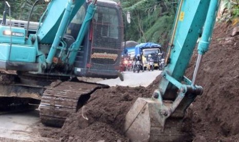 Ekskavator menggali material longsoran di jalan Trenggalek-Ponorogo.