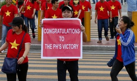 Ekspatriat Vietnam menyeberangi jalan sambil menunjukkan poster dukungan kepada Filipina sebelum keputusan pengadilan arbitrase internasional mengenai Laut Cina Selatan, Selasa, 12 Juli 2016. Vietna mendukung kasus Filipina ini.