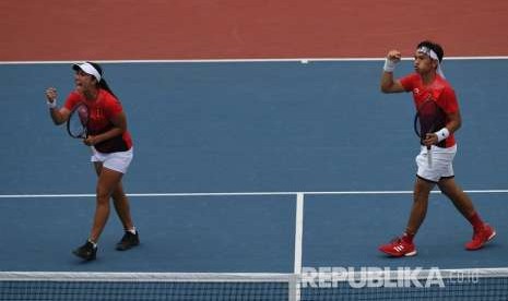 Ekspresi ganda campuran Indonesia Aldila Sutjiadi (kiri) dan Christopher Rungkat seusai meraih poin dari petenis Thailand Luksika Kumkhum dan Sonchat Ratiwatana pada final tenis ganda campuran Asian Games 2018 di Jakabaring Sport City, Palembang, Sumatera Selatan, Sabtu (25/8).