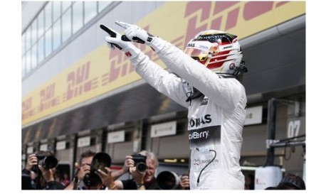 Ekspresi kegembiraan Lewis Hamilton seusai memastikan menempati pole position di GP Inggris.