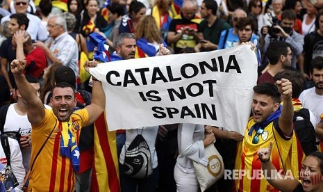 Catalan people unfold a banner to express their support to Catalonia independence.