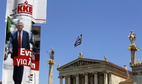 Election campaign posters of Democratic Left and Greece's Communist Party are seen next to the Athens Academy and statues of ancient Greek gods June 13, 2012. Greece holds general parliamentary elections on June 17. European crisis is one of the main theme