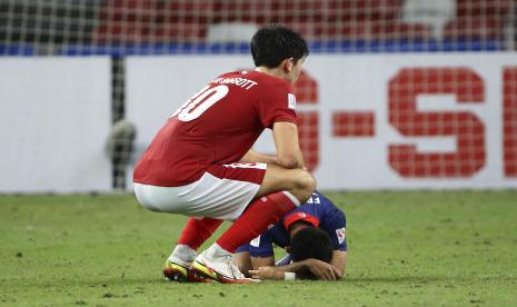 Elkan William Tio Baggott dari Indonesia, kiri, menghibur Faris Ramli dari Singapura pada peluit akhir pertandingan leg kedua semifinal AFF Suzuki Cup 2020 antara Indonesia dan Singapura di Singapura, Sabtu, 25 Desember 2021.