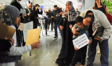 Eman Ali (12 tahun) dari Yaman, kiri tengah berkerudung abu-abu, dan ayahnya Ahmed Ali (kanan) saat tiba di San Francisco International Airport, Ahad, 5 Februari 2017.