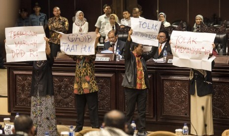 Empat anggota DPD melakukan aksi protes disaksikan Ketua DPD Oesma Sapta Odang (kedua kanan) dan Wakil Ketua DPD Nono Sampono (ketiga kiri) saat pembukaan masa sidang DPD di Komplek Parlemen Senayan, Jakarta, Selasa (11/4).