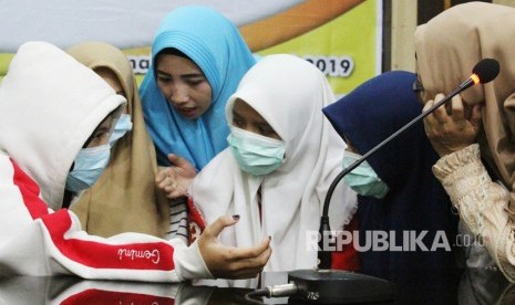 Empat dari 12 siswi SMU yang diduga menjadi pelaku dan saksi dalam kasus penganiayaan siswi SMP berinisial AU (14) berdiskusi dengan kerabat di sela jumpa pers yang digelar di Mapolresta Pontianak, Kalimantan Barat, Rabu (10/4/2019).