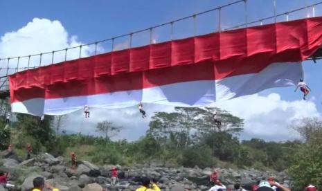 Enam anak yang tergabung dalam Tlaten Sekolah Panjat Tebing Temanggung membentangkan Bendera Merah Putih berukuran besar di Jembatan Sekrikil, Parakan, Kabupaten Temanggung, Jawa Tengah, pada Rabu (17/8/2022). Kegiatan ini menjadi salah satu cara memeriahkan HUT Ke-77 Kemerdekaan RI.