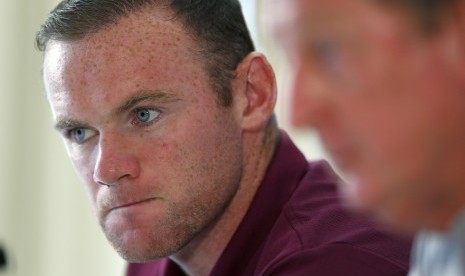 England captain Wayne Rooney (L) listens to manager Roy Hodgson during a news conference at their team hotel in Watford, north of London, September 2, 2014. England will play Norway in a friendly soccer match in London on Wednesday.