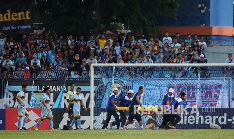 enjaga gawang Persela Lamongan Choirul Huda ditandu petugas kesehatan ketika bertanding melawan Semen Padang dalam lanjutan Gojek Traveloka Liga 1 di Stadion Surajaya Lamongan, Jawa Timur, Minggu (15/10).