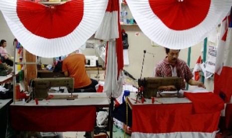 enjahit menyelesaikan pesanan bendera merah putih di Blok V Pasar Senen, Jakarta.