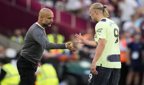  Erling Haaland dari Manchester City, kanan, berjabat tangan dengan pelatih kepala Manchester City Pep Guardiola selama pertandingan sepak bola Liga Inggris antara West Ham United dan Manchester City di Stadion London di London, Inggris,  Senin (8/8/2022) dini hari WIB.