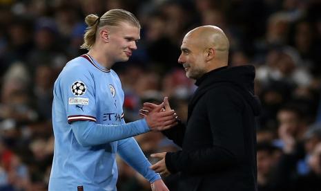 Erling Haaland (kiri) disambut pelatih Manchester City Pep Guardiola saat ia ditarik keluar lapangan selepas mencetak lima gol ke gawang RB Leipzig dalam pertandingan leg kedua 16 besar Liga Champions di Stadion Etihad, Manchester, Rabu (15/3/2023) dini hari WIB.