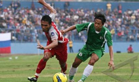 esepakbola Arema Indonesia, Hendro Siswanto (kiri) berebut bola dengan pesepakbola PSMS Medan, Kamil Sembiring (kanan) dalam pertandingan Kompetisi Indonesia Premier League (IPL) di Stadion Gajayana, Malang, Jawa Timur, Rabu (14/12)