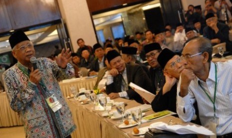 etua Majelis Ulama Indonesia (MUI) Jawa Timur, Abdusshomad Buchori (kiri) membacakan hasil sidang komisi-komisi dalam sidang pleno disela-sela Musyawarah Nasional (Munas) IX Majelis Ulama Indonesia (MUI) di Surabaya, Jawa Timur, Rabu (26/8). 