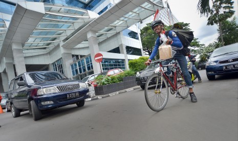 Petugas jasa kurir bersepeda mengayuh sepedanya saat mengantar paket di kawasan Senayan, Jakarta (ilustrasi)